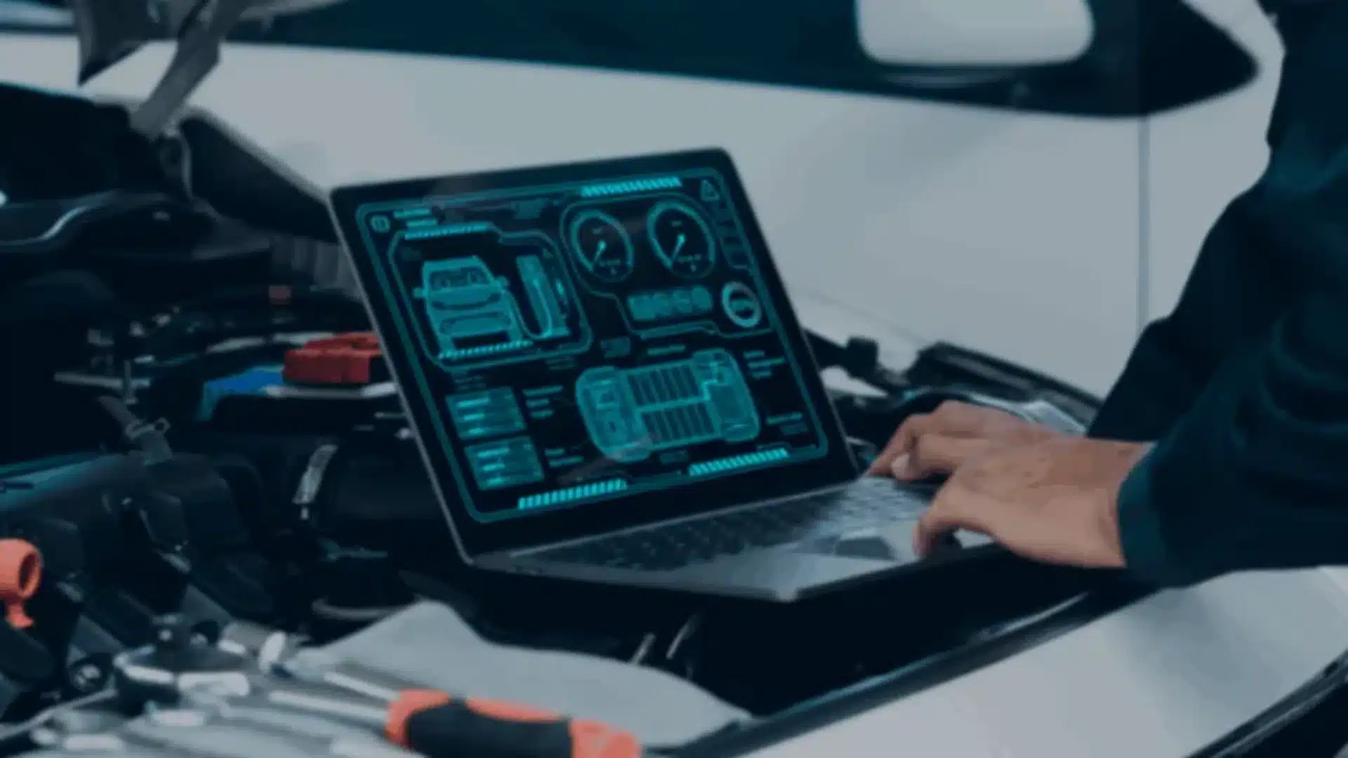A person working on a laptop displaying automotive diagnostics, with a car engine in the background, illustrating React Native automotive app development.