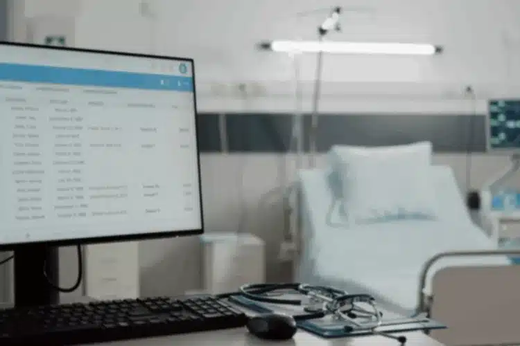 A computer screen displaying patient information in a hospital room, symbolizing Javascript healthcare app development.