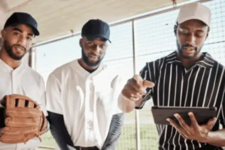 Baseball players analyze a tablet, showing a sports analytics platform for competitive advantage.