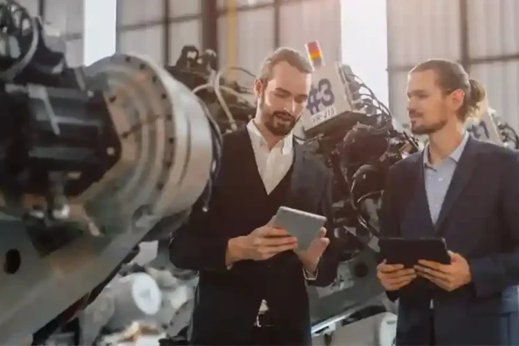 Engineers using tablets in factory with Manufacturing Execution System for real-time production.