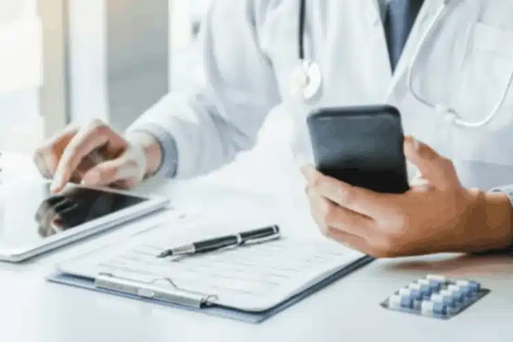 A doctor using a tablet and smartphone, representing the use of technology in healthcare, relevant to React Native healthcare app development.