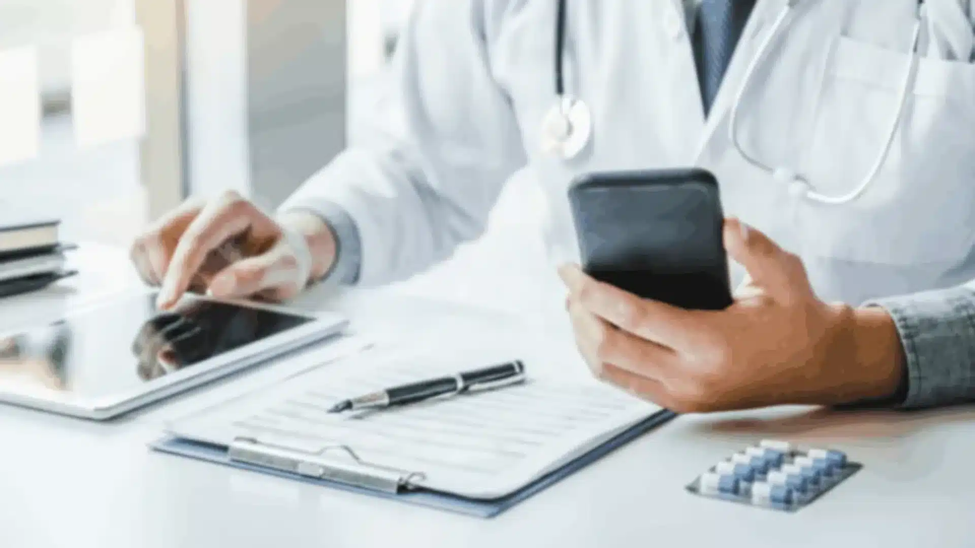 A doctor using a tablet and smartphone, representing the use of technology in healthcare, relevant to React Native healthcare app development.