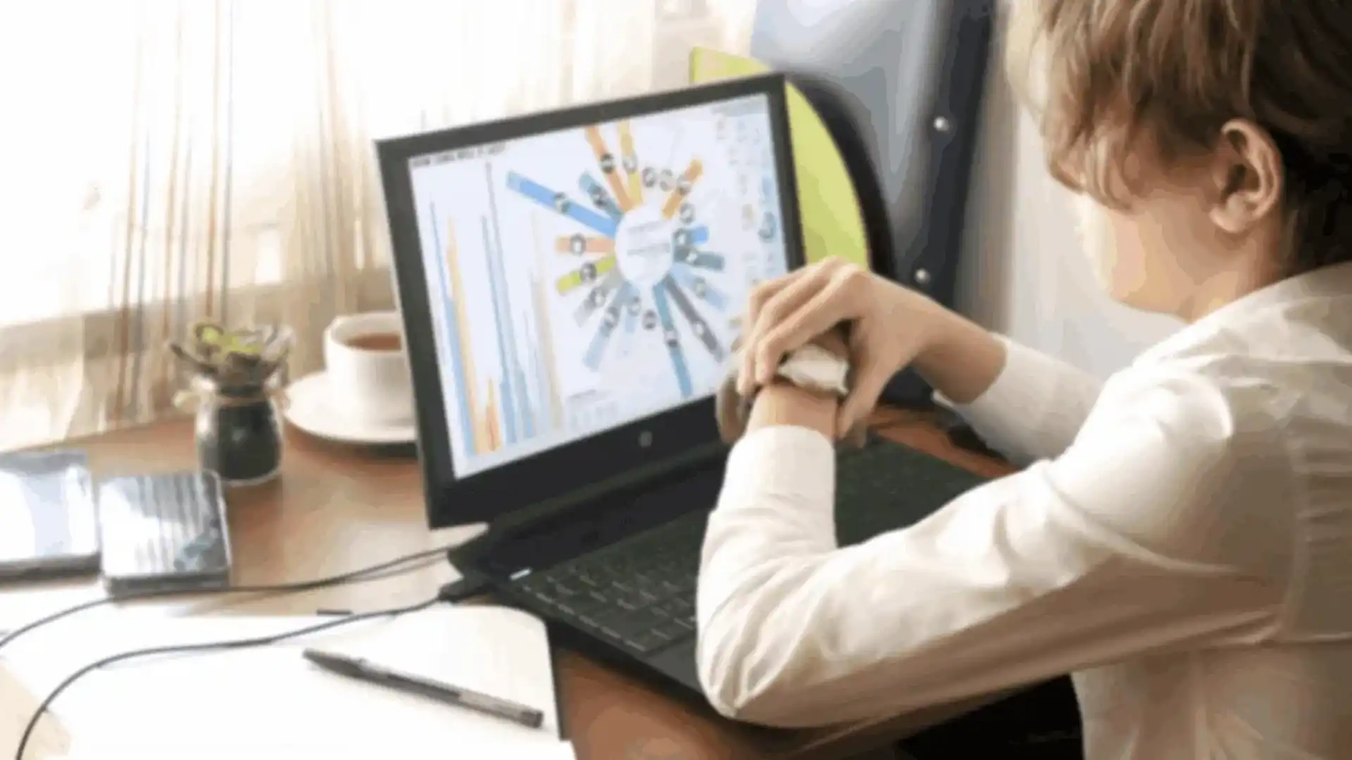 A person uses an advanced sports analytics app on a laptop, showing charts and data.