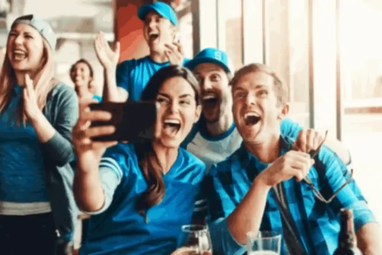 Excited fans taking selfie at game, showcasing engagement benefits of sports app development solutions.