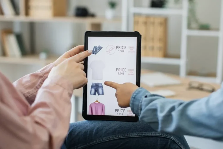 Two people point at clothes on a tablet, showcasing a user-friendly Retail Platform MVP.