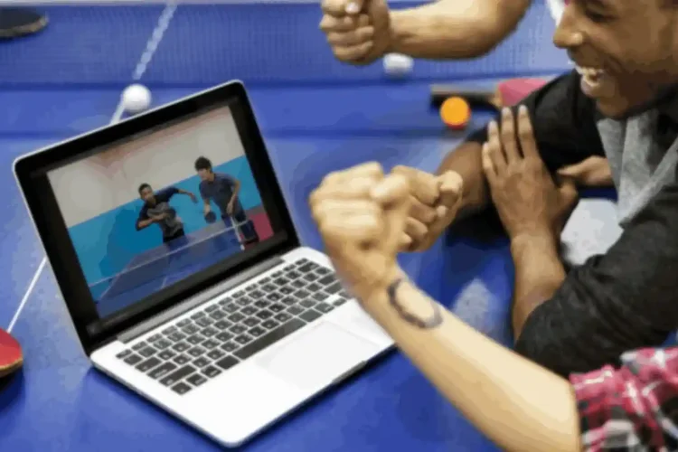 Friends watching a sports game on a laptop, powered by sports data API development.
