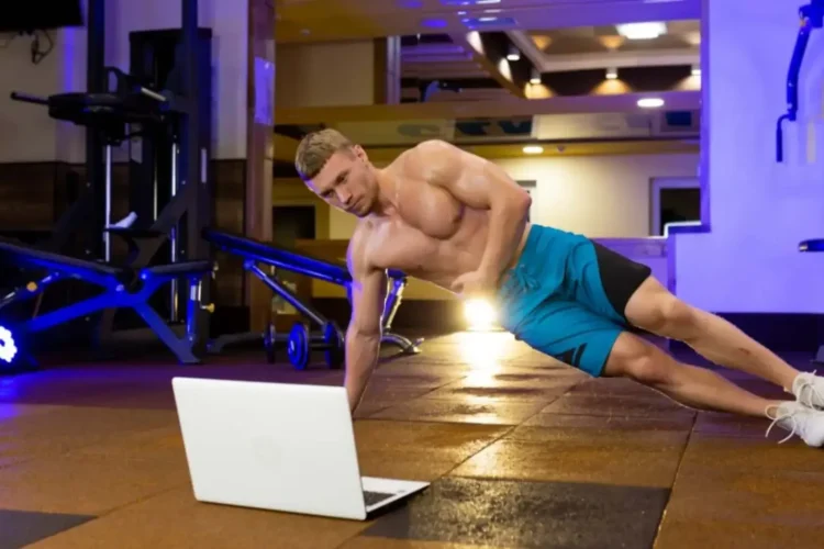 A person does a side plank in front of a laptop, an example of a Fitness App MVP.