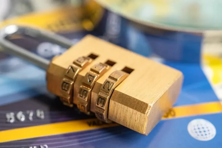 A combination lock rests on a credit card, symbolizing secure financial services database development.