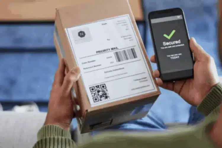 Hands hold a package and a smartphone displaying a 